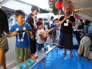 復活した縁日で射的をする親子